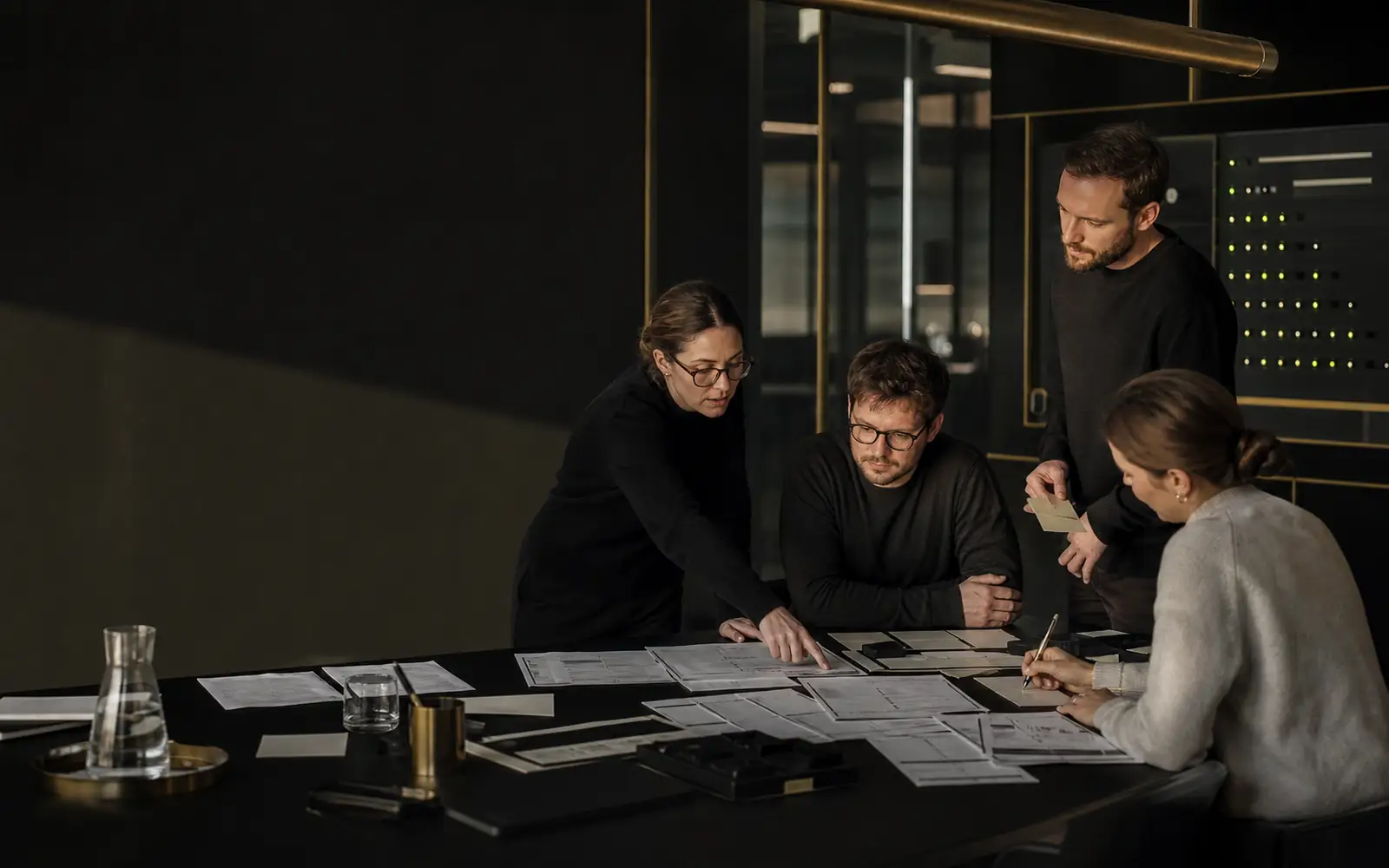 Leadership team reviewing Novixx around a real operating workflow in a restrained dark workspace
